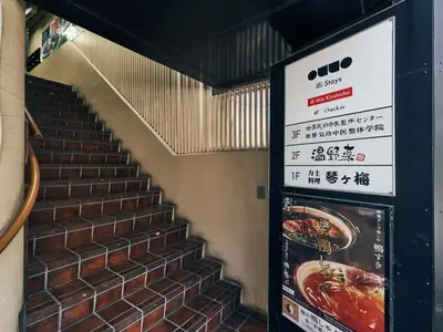 a stair case with a sign next to a brick wall at illi Mia Kinshicho in Tokyo