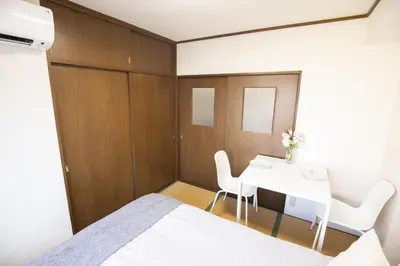 a bedroom with a bed and a table and chairs at \u6771\u4e2d\u91ce\u99c5\u5f92\u6b693\u5206 \u4ea4\u901a\u81f3\u4fbf \u4e0b\u753a\u30b0\u30eb\u30e1 \u5546\u5e97\u8857\u30b7\u30e7\u30c3\u30d4\u30f3\u30b0\u5bbf YoEh in Tokyo
