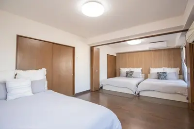 a bedroom with two beds with white sheets at \u5317\u65b0\u5bbf\u5f92\u6b693\u5206 \u4ea4\u901a\u81f3\u4fbf \u4e0b\u753a\u30b0\u30eb\u30e1 \u5546\u5e97\u8857\u30b7\u30e7\u30c3\u30d4\u30f3\u30b0\u5bbf S02c in Tokyo