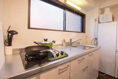 a kitchen with a sink and a pot on a stove at \u5317\u65b0\u5bbf\u5f92\u6b693\u5206 \u4ea4\u901a\u81f3\u4fbf \u4e0b\u753a\u30b0\u30eb\u30e1 \u5546\u5e97\u8857\u30b7\u30e7\u30c3\u30d4\u30f3\u30b0\u5bbf S02c in Tokyo