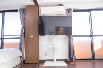 a bedroom with a bed and some windows at \u5317\u65b0\u5bbf\u5f92\u6b693\u5206 \u4ea4\u901a\u81f3\u4fbf \u4e0b\u753a\u30b0\u30eb\u30e1 \u5546\u5e97\u8857\u30b7\u30e7\u30c3\u30d4\u30f3\u30b0\u5bbf S02c in Tokyo