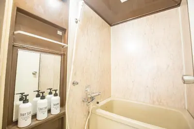 a bathroom with a tub and three bottles of soap at \u5317\u65b0\u5bbf\u5f92\u6b693\u5206 \u4ea4\u901a\u81f3\u4fbf \u4e0b\u753a\u30b0\u30eb\u30e1 \u5546\u5e97\u8857\u30b7\u30e7\u30c3\u30d4\u30f3\u30b0\u5bbf S02c in Tokyo