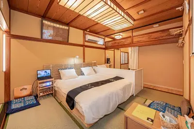 a bedroom with a large bed and a television at Hotel Ginnan in Tokyo