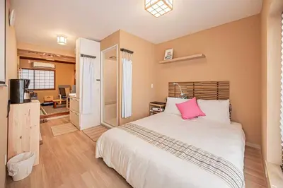 a bedroom with a large bed with a pink pillow at Hotel Ginnan in Tokyo