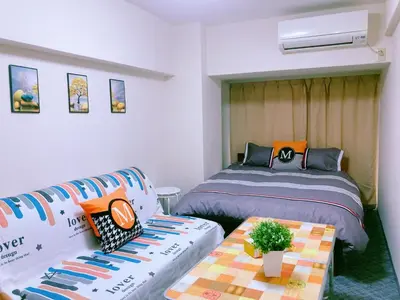 a bedroom with two beds and a table and a couch at Shinjuku House-1 in Tokyo