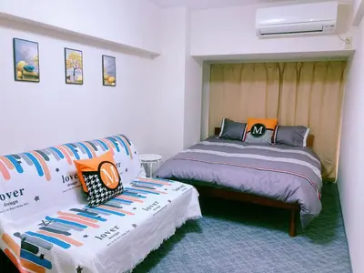 a bedroom with two beds and a couch in it at Shinjuku House-1 in Tokyo