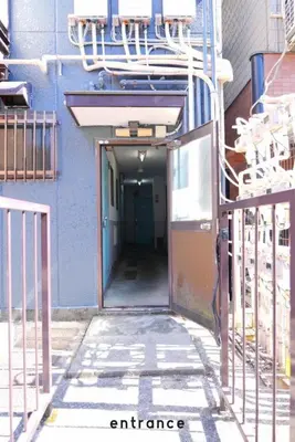 an entrance to a building with a blue wall at Jetset haneda 105 in Tokyo