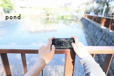 a person taking a picture of the water with a cell phone at Jetset haneda 105 in Tokyo