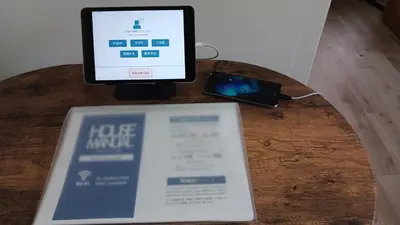 a tablet computer sitting on top of a table with a book at Jetset haneda 105 in Tokyo