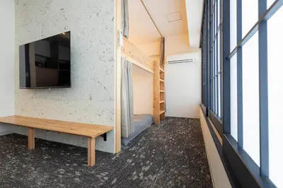 a room with a bench and a tv on a wall at \u30ea\u30bf\u30a4\u30f3\u4e2d\u4e95 in Tokyo