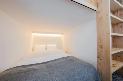 a small bedroom with a bed and wooden shelves at \u30ea\u30bf\u30a4\u30f3\u4e2d\u4e95 in Tokyo