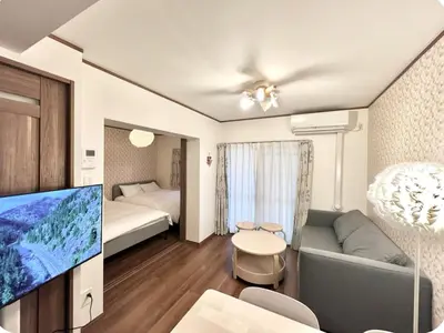 a living room with a couch and a bed and a tv at Kitashinjuku 107-SJ0014 in Tokyo