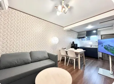 a living room with a couch and a table and a kitchen at Kitashinjuku 107-SJ0014 in Tokyo