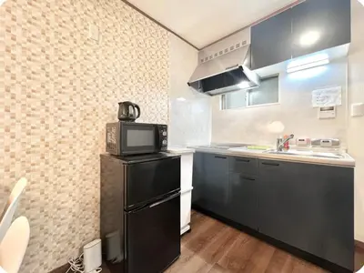 a kitchen with a black refrigerator and a microwave at Kitashinjuku 107-SJ0014 in Tokyo