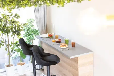 a dining table with two black chairs in front of a window at Parkview, 3min by Train to Shibuya, 5min by Train to Shinjuku in Tokyo