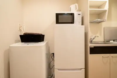 a microwave on top of a refrigerator in a kitchen at Belle Lead 106 in Tokyo