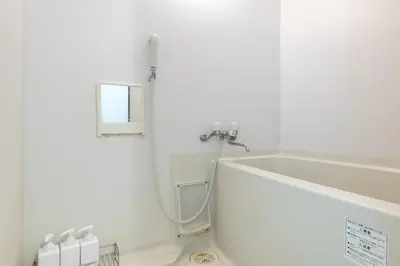 a white bathroom with a tub and a sink at Max 9 people 8 minutes from Shibuya 5 minutes from Shinjuku 1 minute from Harajuku 4 minutes walk from the station Room Sakura in Tokyo