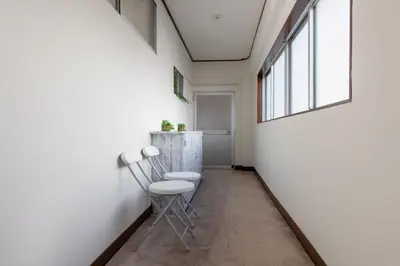 a hallway with two chairs and a window at Max 9 people 8 minutes from Shibuya 5 minutes from Shinjuku 1 minute from Harajuku 4 minutes walk from the station Room Sakura in Tokyo