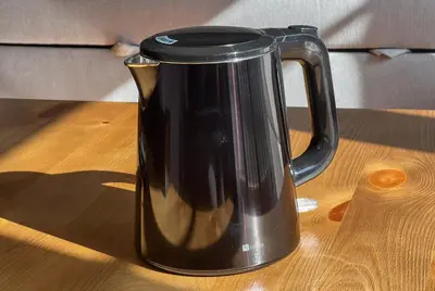 a black coffee pot sitting on a wooden table at Max 9 people 8 minutes from Shibuya 5 minutes from Shinjuku 1 minute from Harajuku 4 minutes walk from the station Room Sakura in Tokyo