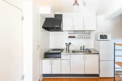 a kitchen with white cabinets and a sink at Max 9 people 8 minutes from Shibuya 5 minutes from Shinjuku 1 minute from Harajuku 4 minutes walk from the station Room Sakura in Tokyo