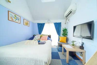 a blue room with a bed and a flat screen tv at SC 202 Cozy Private Stay with Loft Near Station Free WiFi in Tokyo