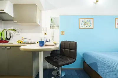 a small kitchen with a table and a chair next to a bed at SC 202 Cozy Private Stay with Loft Near Station Free WiFi in Tokyo