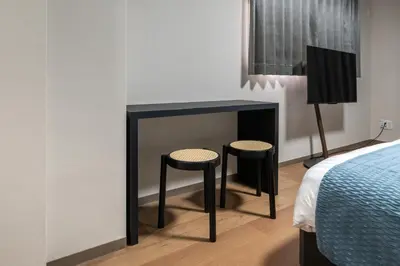 a desk with two stools next to a fireplace at JAPT Gotanda in Tokyo