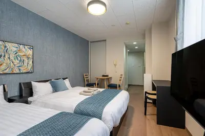 a hotel room with two beds and a table at JAPT Gotanda in Tokyo