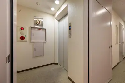 a corridor of an elevator with the number eight on the wall at JAPT Gotanda in Tokyo