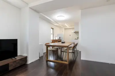 a dining room with a table and a tv at HOTEL KOMACHI TOKYO Higashi Nippori in Tokyo