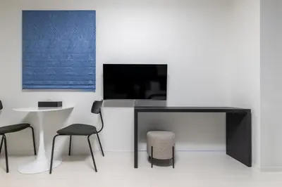 a living room with a table and chairs and a tv at HOTEL KOMACHI TOKYO Higashi Nippori in Tokyo