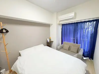 a bedroom with a white bed and a chair and a window at \u30b5\u30af\u30e9\u30b7\u30e3\u30c9\u30a6\u6771\u6c60\u888b in Tokyo