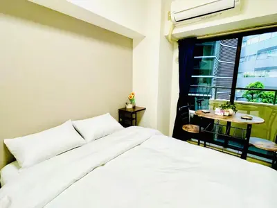 a bedroom with a bed and a window with a table at \u30b5\u30af\u30e9\u30b7\u30e3\u30c9\u30a6\u6771\u6c60\u888b in Tokyo
