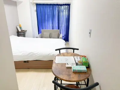 a room with a table and a bed and a table and chairs at \u30b5\u30af\u30e9\u30b7\u30e3\u30c9\u30a6\u6771\u6c60\u888b in Tokyo