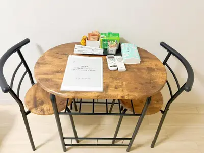 a round wooden table with a black metal chair at \u30b5\u30af\u30e9\u30b7\u30e3\u30c9\u30a6\u6771\u6c60\u888b in Tokyo