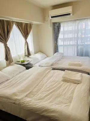 a bedroom with two beds and a window at Ueno Uguisudani Tokan in Tokyo