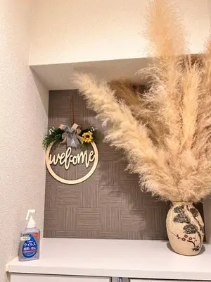 a shelf with a welcome sign and a vase with feathers at Ueno Uguisudani Tokan in Tokyo