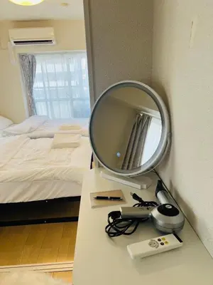 a mirror sitting on a table next to a bed at Ueno Uguisudani Tokan in Tokyo