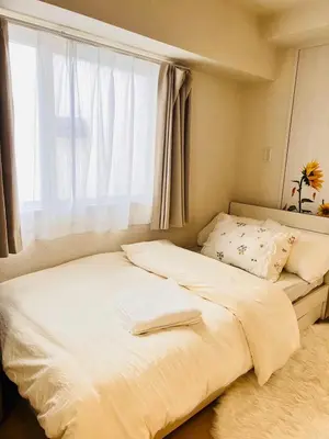 a bedroom with a large bed with a window at Ueno Uguisudani Tokan in Tokyo