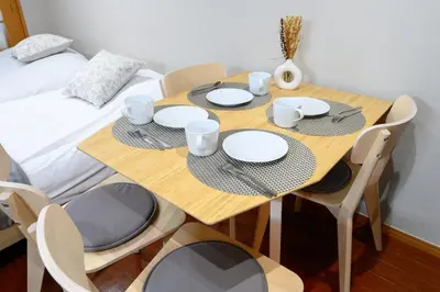 a wooden table with four chairs and plates on it at Near Shibuya Station 4Beds 5Max A175 in Tokyo