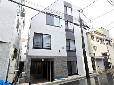 a white building with black windows on a street at HeureuxShiinamachi - Vacation STAY 19768 in Tokyo
