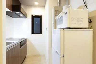 a kitchen with a refrigerator and a microwave at HeureuxShiinamachi - Vacation STAY 19768 in Tokyo