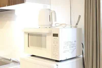 a microwave oven sitting on top of a refrigerator at HeureuxShiinamachi - Vacation STAY 19769 in Tokyo