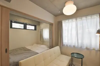 a bedroom with a couch and a table and a window at La Residence East Tokyo201 - Vacation STAY 19856 in Tokyo