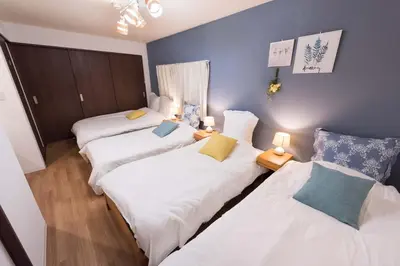 three beds in a room with blue walls at Wakabayashi house in Tokyo