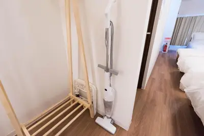 a room with a vacuum cleaner next to two beds at Wakabayashi house in Tokyo