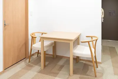 a wooden table and two chairs and a table and a door at \u6771\u6025\u30b9\u30c6\u30a4\u56db\u8c37 in Tokyo