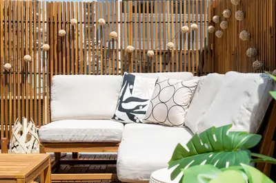 a white couch with pillows on a patio at \u6674\u30ec\u5c4b\u6d45\u8349 Hareya Asakusa in Tokyo