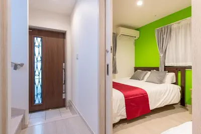 a bedroom with a bed and a green wall at Detached house in Oshima 4chome, one train ride to Shinjuku \u5927\u5cf64\u4e01\u76ee in Tokyo