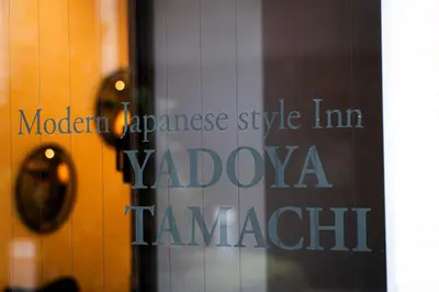 a glass window with the words molomonas style inn vadalatown at YadoyaTamachi 101 in Tokyo